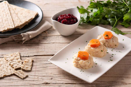 Traditional Jewish gefilte fish with beetroot and matzah bread on wooden tableの写真素材
