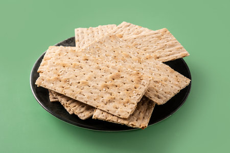 Traditional matzah bread on green background