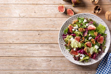Figs salad with cheese and walnuts on rustic wooden tableの写真素材