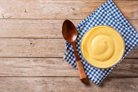 Pastry cream in a bowl on wooden tableの写真素材