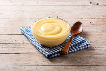 Pastry cream in a bowl on wooden tableの写真素材
