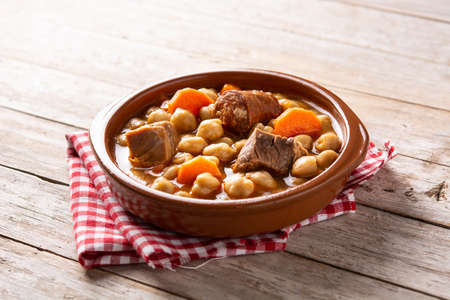 Traditional Spanish cocido madrileÃ±o in bowl on wooden tableの写真素材