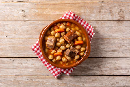 Traditional Spanish cocido madrileÃ±o in bowl on wooden tableの写真素材