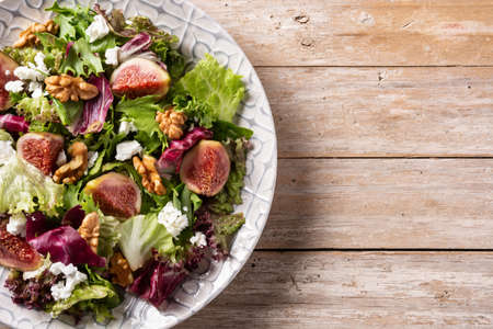 Figs salad with cheese and walnuts on rustic wooden tableの写真素材