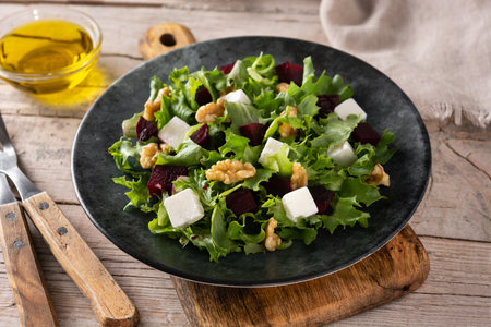 Beetroot salad with feta cheese, lettuce and walnuts on wooden tableの写真素材