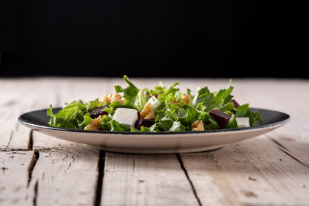 Beetroot salad with feta cheese, lettuce and walnuts on rustic wooden tableの写真素材