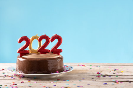 2022 cake and ornaments on wooden table and blue backgroundの写真素材