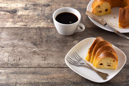 Traditional bundt cake with raisins on wooden table