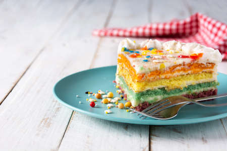 Rainbow layer cake on wooden table