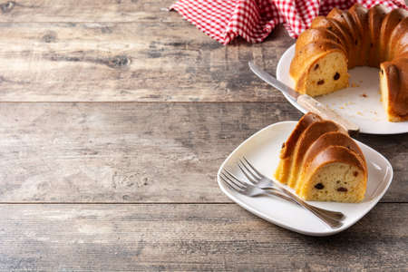 Traditional bundt cake piece with raisins on wooden tableの写真素材