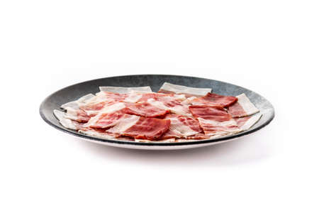 Spanish serrano ham slice on black plate isolated on white backgroundの写真素材