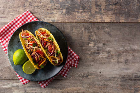 Traditional Mexican tacos with meat and vegetables on wooden tableの写真素材