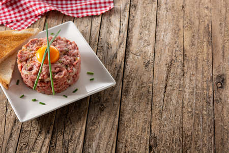 Beef steak tartare on wooden tableの写真素材