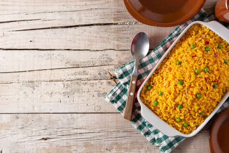 Traditional Mexican rice served with green peas on wooden tableの写真素材