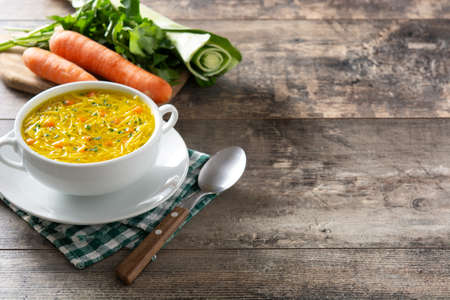 Chicken noodle soup in white bowl on wooden tableの写真素材