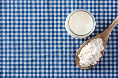 Fresh cottage cheese on blue tablecloth background