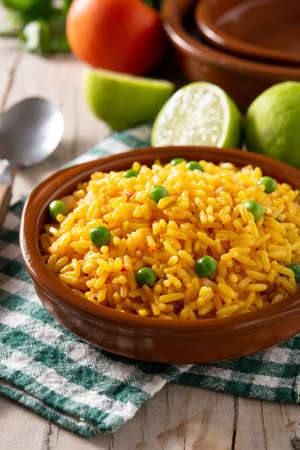 Traditional Mexican rice served with green peas on wooden tableの写真素材