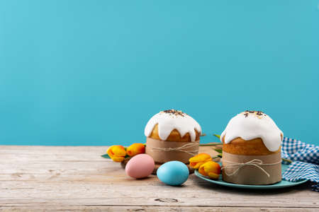 Traditional Easter cake, colorful eggs and tulips on wooden tableの写真素材