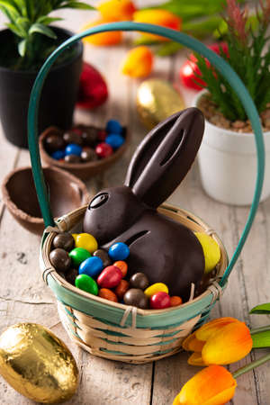 Easter chocolate bunny and colorful eggs on wooden table