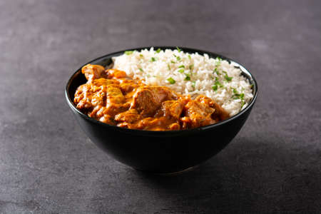 Indian butter chicken in black bowl on black backgroundの写真素材