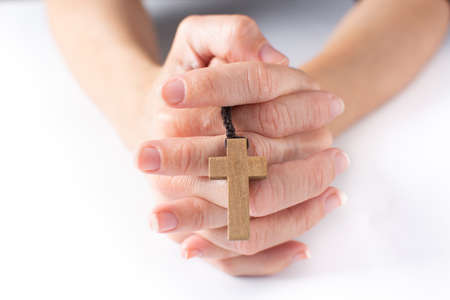 Woman praying with rosary catholic cross on white backgroundの写真素材