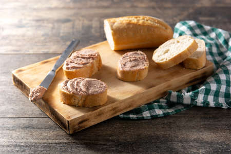 Toasted bread with pork liver pate on wooden table