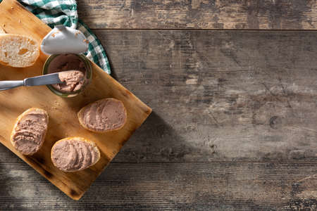 Toasted bread with pork liver pate on wooden table