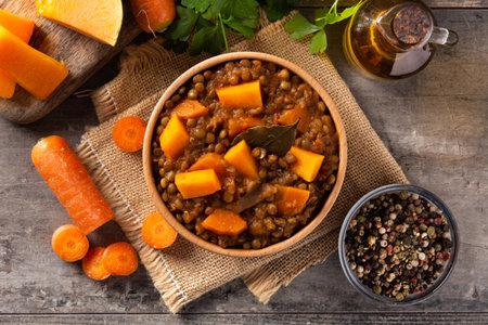 Lentil stew ragout with pumpkin and carrot in bowl on wooden tableの写真素材