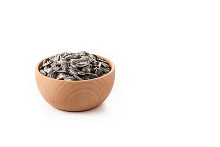 Sunflower seeds in wooden bowl isolated on white background. copy-space