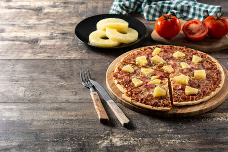 Hawaiian pizza with pineapple,ham and cheese on wooden tableの写真素材