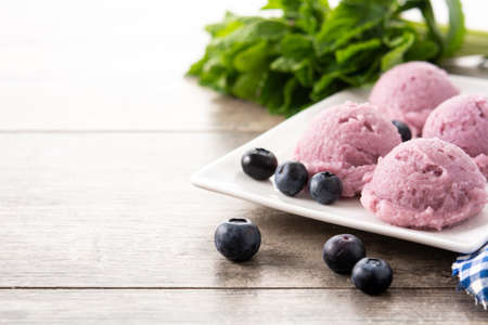 Blueberry ice cream scoops on wooden tableの写真素材