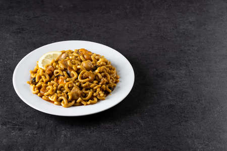Traditional Spanish fideua on black stone background. paella noodle.の写真素材