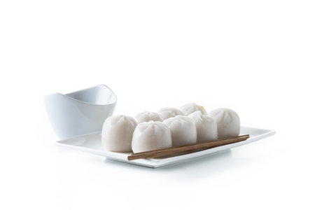 Steamed dumplings on plate and soy sauce isolated on white backgroundの写真素材