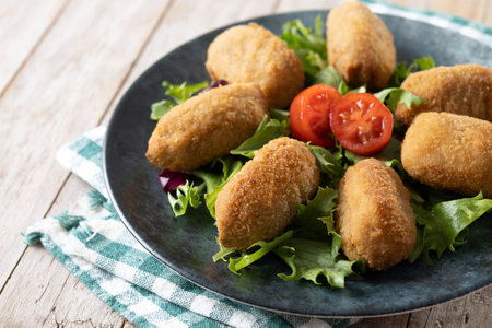Traditional spanish fried croquettes on wooden tableの写真素材