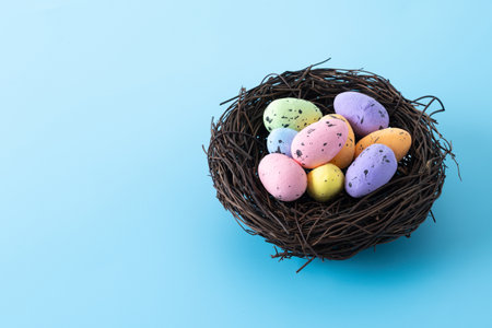Colorful Easter eggs inside a nest on blue background