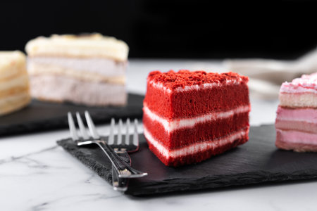 Set of cake portions, velvet, strawberry cake, carrot cake and chocolate cake on marbleの写真素材