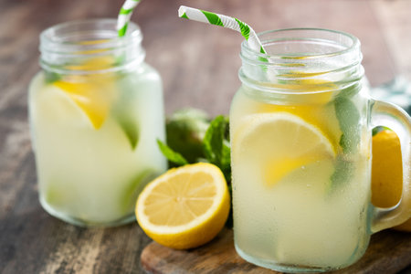 Lemonade drink in a jar glass and ingredients on wooden tableの写真素材