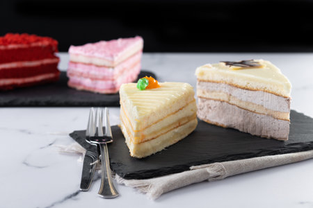 Set of cake portions, velvet, strawberry cake, carrot cake and chocolate cake on marbleの写真素材
