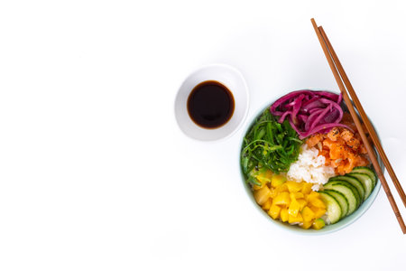 Poke bowl with rice, salmon, cucumber, mango, onion, wakame salad, poppy seeds and sunflower seeds isolated on white backgroundの写真素材
