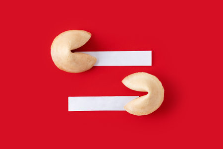 Traditional fortune cookies with white empty paper for text on red backgroundの写真素材