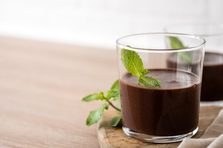 Chocolate mousse dessert garnished with mint leaf on wooden tableの写真素材