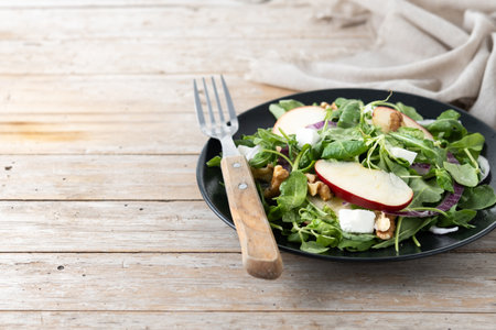 Autumn salad with apples and walnuts on wooden tableの写真素材