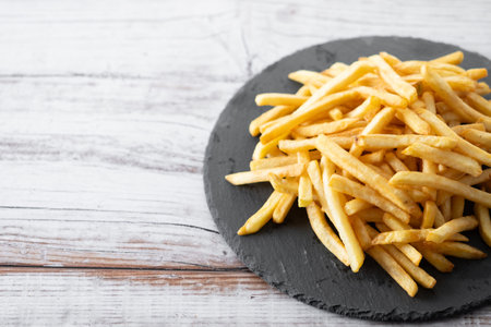 Fried potatoes, french fries on wooden table