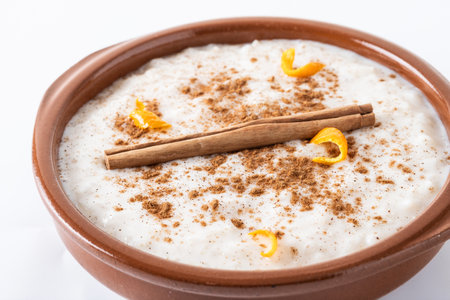 Rice pudding. Rice pudding with cinnamon in clay bowl isolated on white backgroundの写真素材