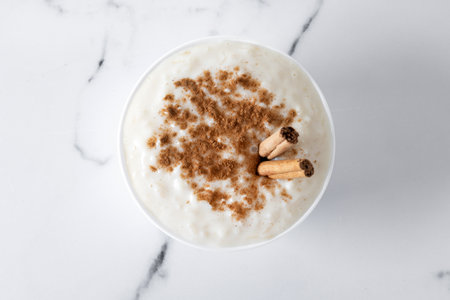 Rice pudding. Rice pudding with cinnamon in clay bowl on white marbleの写真素材