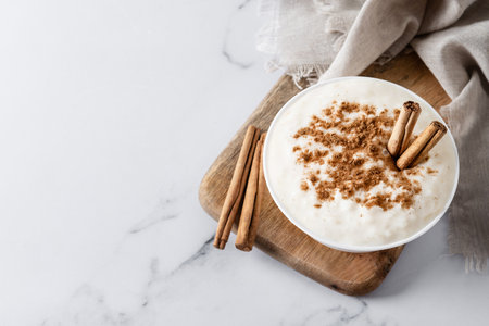 Rice pudding. Rice pudding with cinnamon in clay bowl on white marble. top viewの写真素材