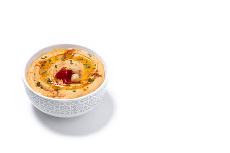 Roasted red pepper hummus in white bowl isolated on white backgroundの写真素材