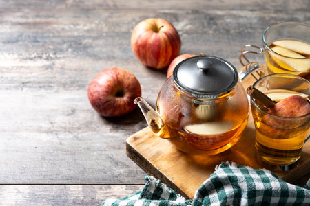Hot apple drink with spices on wooden tableの写真素材