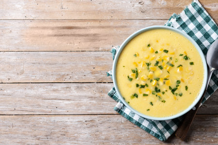 Corn soup in green bowl on wooden tableの写真素材