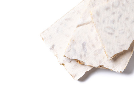 Traditional Christmas sweet, pieces of delicious almond nougat isoalted on white backgroundの写真素材